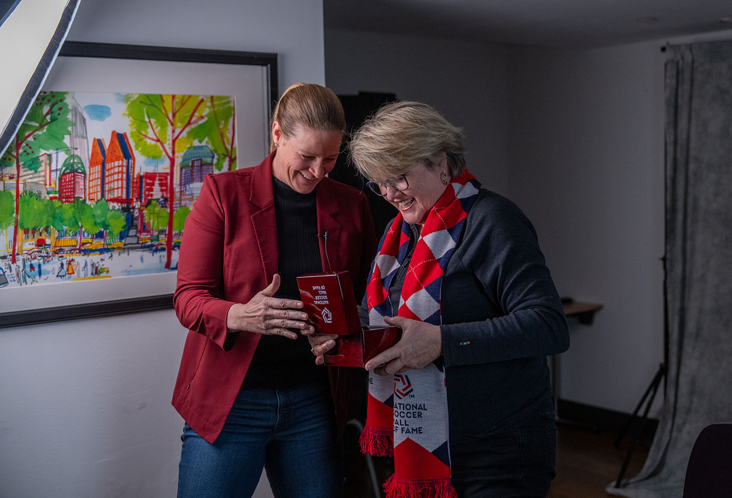 Cindy Parlow Cone and Mary Harvey looking at the Hall of Fame medal.