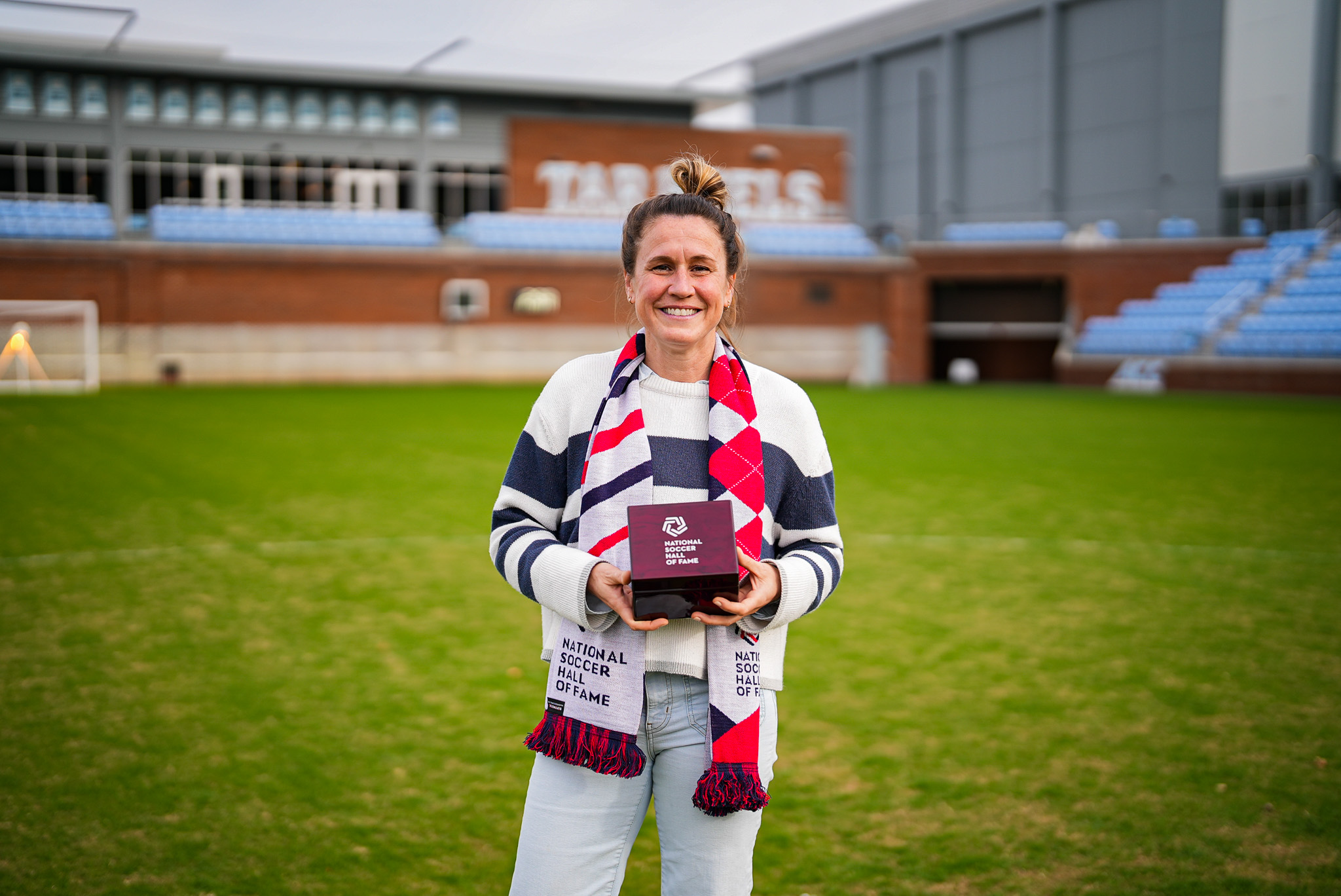 Woman standing on a soccer field.