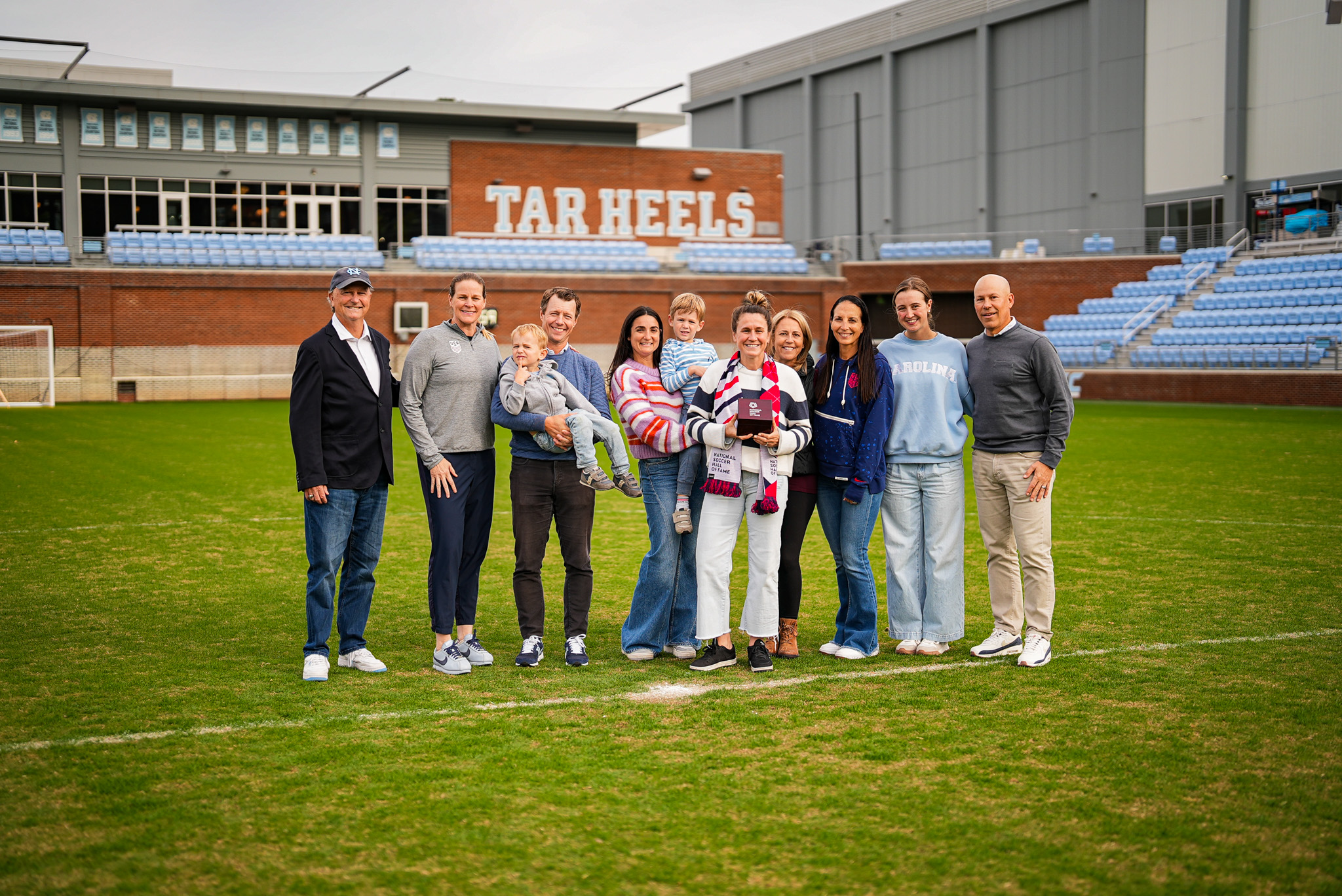 People standing together on a soccer field.