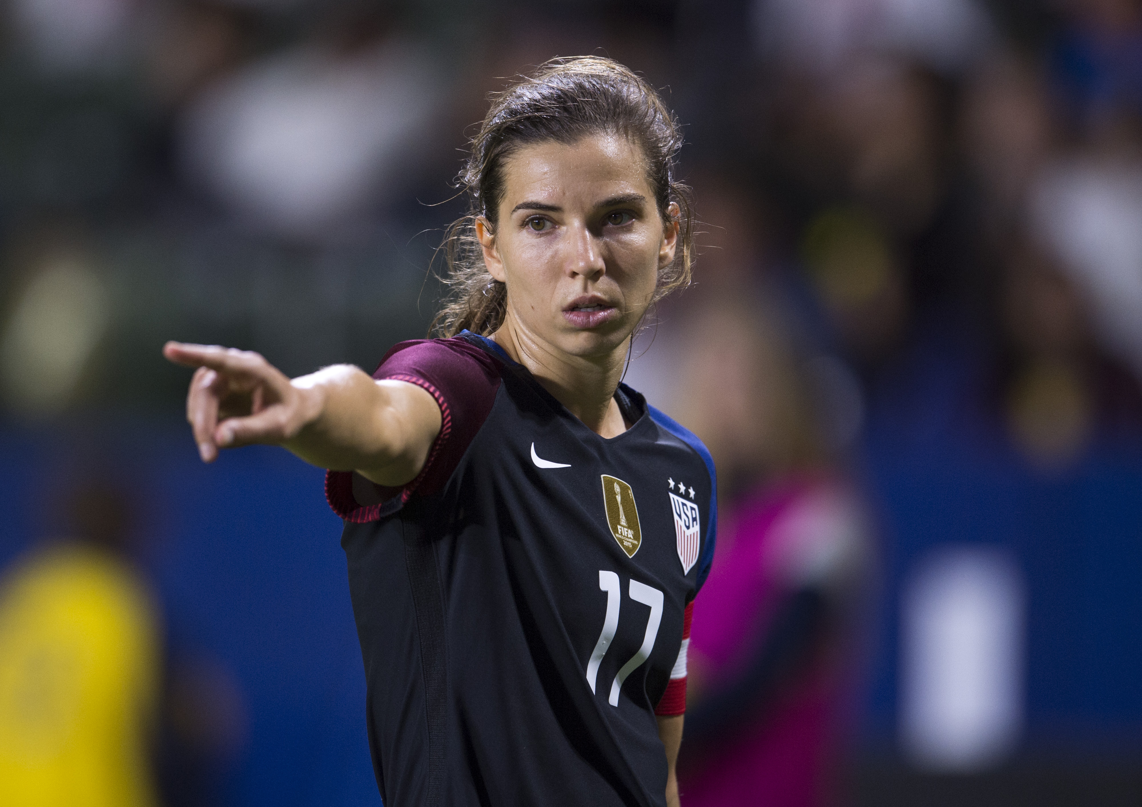 A soccer player (Tobin Heath) wearing warmups for the US Women's National Team during the playing of the national anthem before a match.